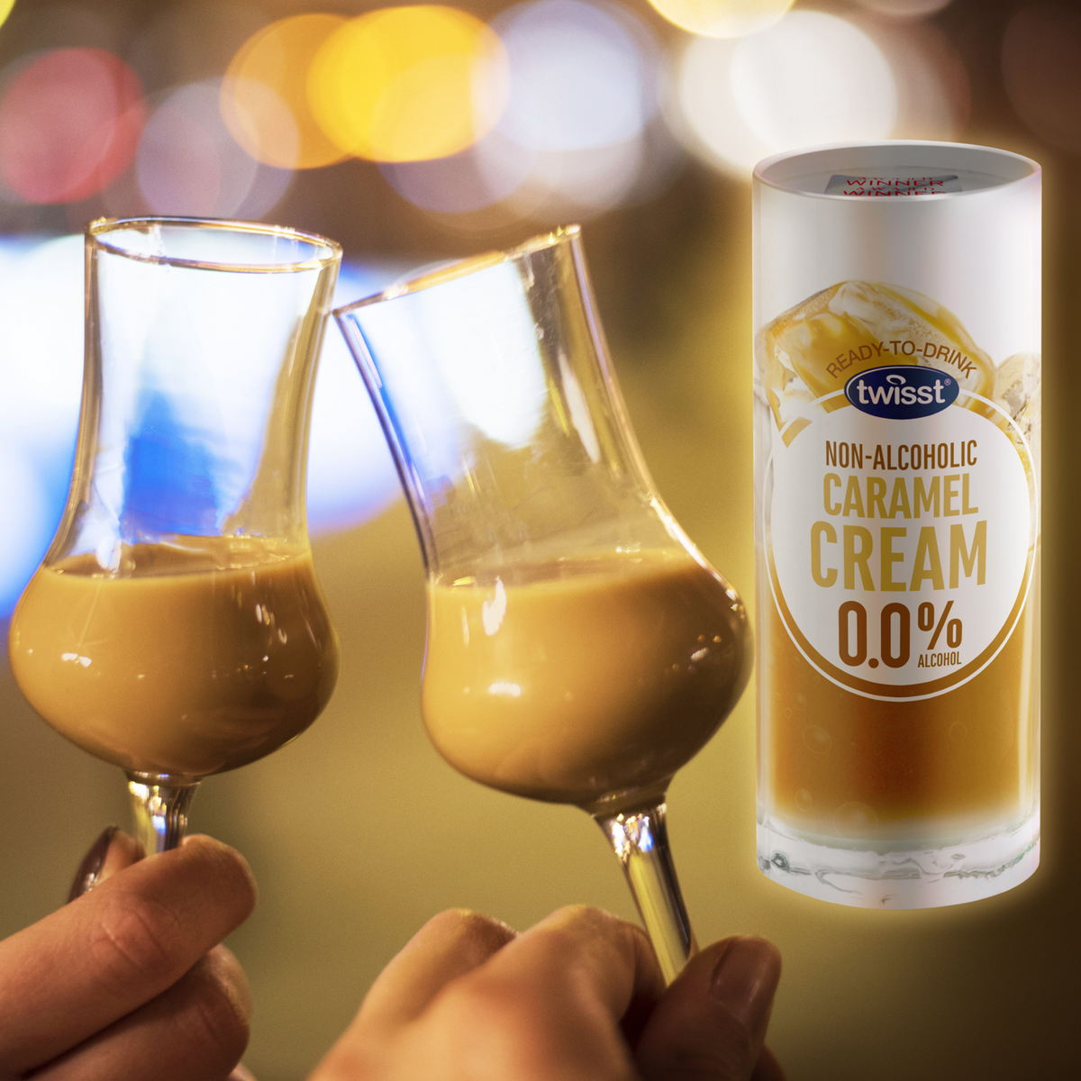 Two glasses of Twisst Caramel Cream alcohol free cream liqueur raised in a toast next to the 235ml can