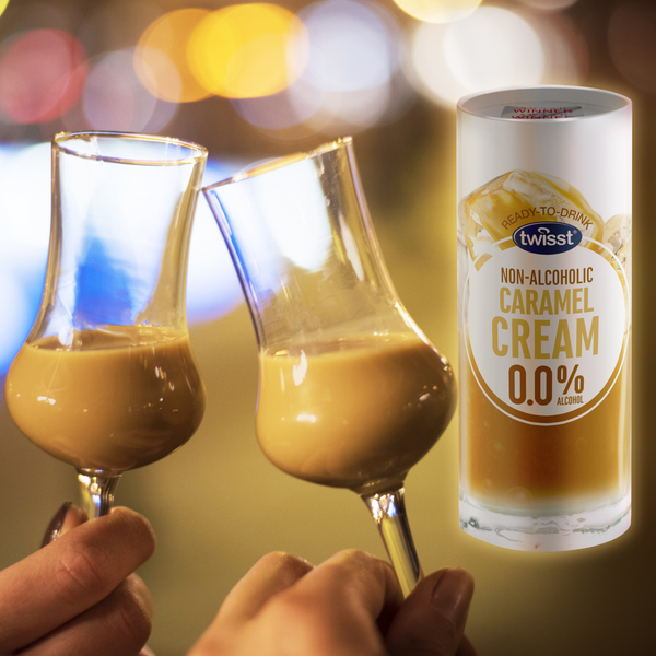 Two glasses of Twisst Caramel Cream alcohol free cream liqueur raised in a toast next to the 235ml can